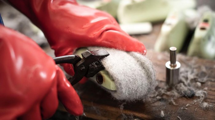 Giovani artigiani (lvh.apa) e giovani albergatori (HGJ) in visita alla Scuola media del convento delle Orsoline a Brunico Persona rimuove lana infeltrita dalla suola della scarpa con pinza