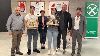 News Sei persone posano con regali davanti a divise sportive e striscione Raiffeisen