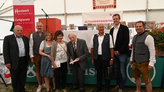 News Gruppo di otto persone a evento artigianale con abiti tradizionali e formali