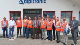 News Gruppo di uomini con giubbotti di sicurezza davanti all'edificio Alpitronic