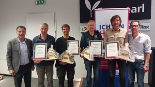 News Sei uomini che ricevono premi con certificati e regali in un ambiente interno