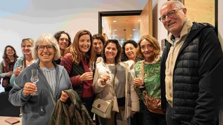 News Gruppe von Erwachsenen, die mit Gläsern anstoßen und lächeln in einem Raum