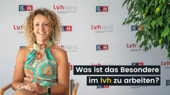 Jobs Frau mit buntem Kleid sitzt und lächelt vor lvh-Hintergrund