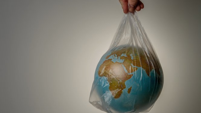 Home Erde in einer Plastiktüte gehalten, symbolisch für Umweltschutz