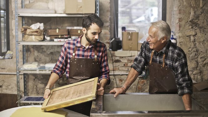 Home Junger und älterer Mann bei der traditionellen Papierherstellung in Werkstatt