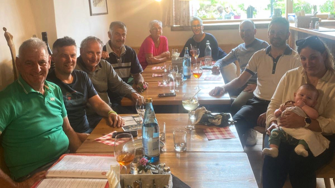Home Gruppe von Menschen sitzt an Holztischen in einem Restaurant, eine Frau hält ein Baby