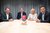 Home Vier Personen sitzen hinter einem Tisch mit einem Great Place to Work-Zertifikat