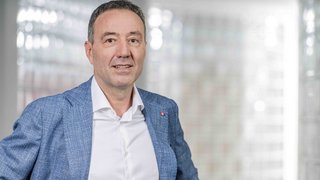 News Uomo con giacca blu davanti a sfondo sfocato