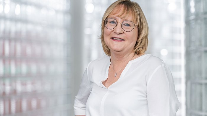 Mittelschule Mals: Jugendliche entdecken Berufe im Handwerk und Gastgewerbe Porträt einer lächelnden älteren Frau mit Brille vor hellem Hintergrund