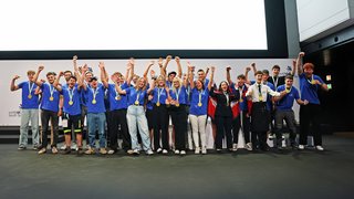 News Junge Gewinner mit Medaillen jubeln auf der Bühne bei einer Preisverleihung