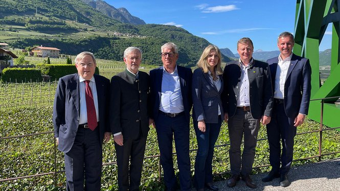 Home Sechs Personen posieren vor Berglandschaft und klarem Himmel