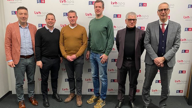 Home Sechs Männer stehen vor einer Wand mit lvhapa-Logo