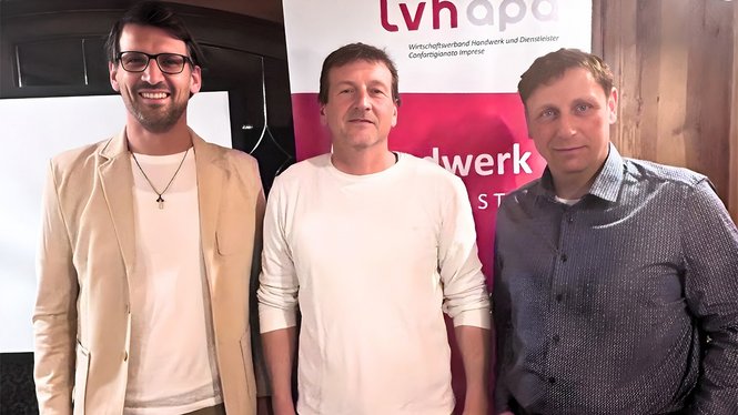 Home Drei Männer stehen vor lvhapa-Banner bei einer Veranstaltung