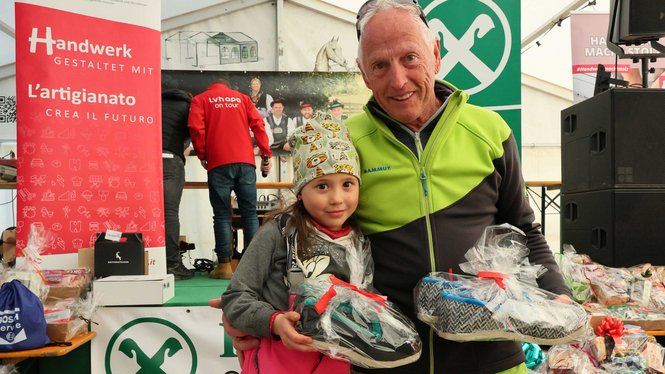 Home Älterer Mann und Kind mit Geschenkpaketen bei Handwerksveranstaltung