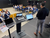 Home Mann hält Präsentation vor sitzendem Publikum in einem Konferenzraum
