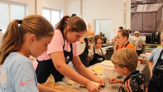 News Bambini preparano dolci arrotolando la pasta in una cucina