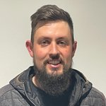 Unterland Porträt eines Mannes mit kurzem Haar und Bart vor weißem Hintergrund