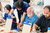Home Menschen arbeiten in einem Workshop mit Holzplatten und blauen Klemmen