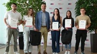 News Gruppe junger Menschen mit Diplomen und Rucksäcken vor LVH-Hintergrund