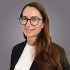 Tirocini in azienda Ritratto di donna con lunghi capelli castani e occhiali su sfondo grigio