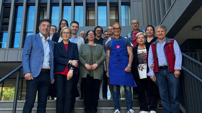 Home Gruppenfoto von 16 Personen vor einem modernen Gebäude