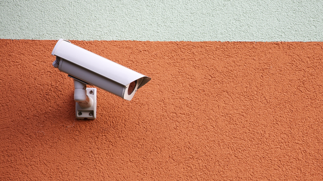 Home Weiße Überwachungskamera an einer orangefarbenen Wand