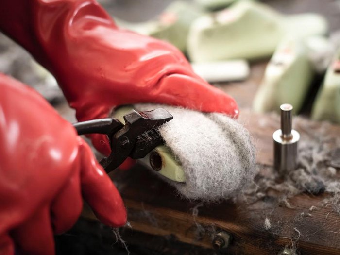 Giovani artigiani (lvh.apa) e giovani albergatori (HGJ) in visita alla Scuola media del convento delle Orsoline a Brunico Persona rimuove lana infeltrita dalla suola della scarpa con pinza