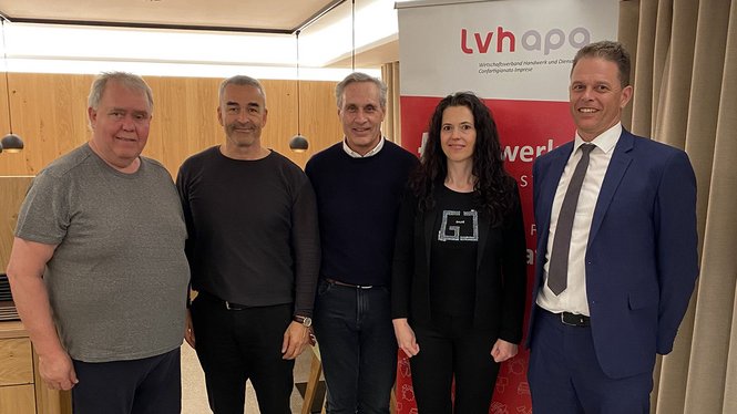 Home Fünf Personen stehen vor einem lvh apo Banner in einem Konferenzraum