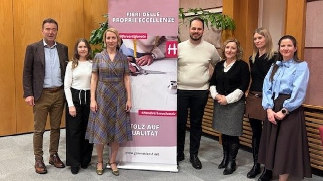 Home Gruppe von sieben Personen steht vor einem Werbebanner in einem Büro