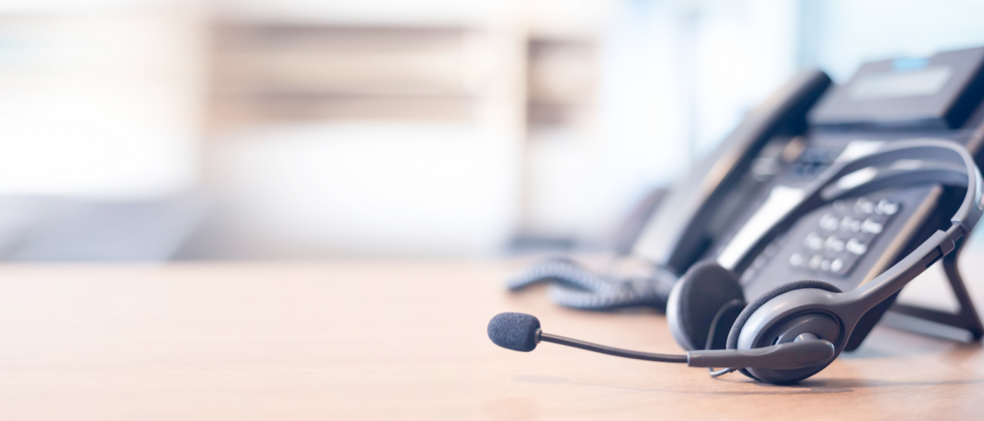 Home Headset vor Telefon auf einem Bürorahmen