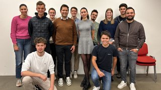 News Gruppe von zwölf lächelnden jungen Erwachsenen vor weißer Wand