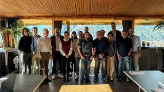 News Foto di gruppo di 15 persone in una stanza con vista sulle montagne