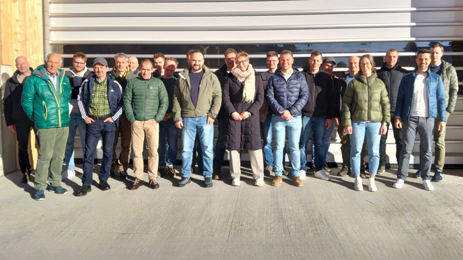 Home Gruppenfoto von 22 Personen vor einer großen Garagentür