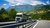Home Lastwagen auf einer Autobahn vor einer grünen Berglandschaft