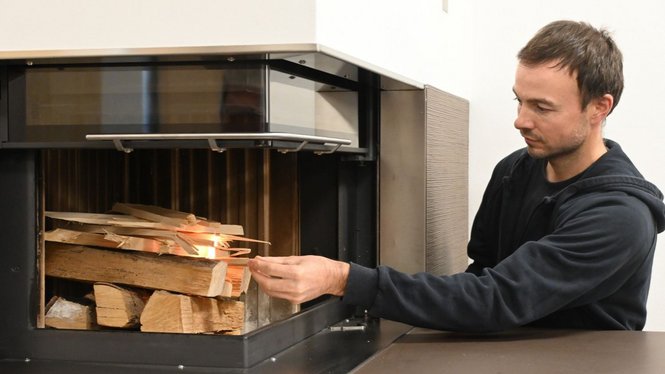 Home Mann legt Anzündholz in einen Kaminofen