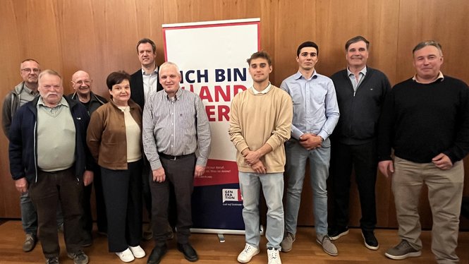 Home Gruppe von zehn Personen steht vor einer Holzpaneelwand mit einem Werbebanner