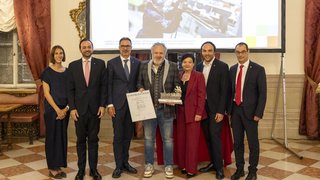 News Gruppe von sieben Personen bei einer Auszeichnung mit Urkunde und Trophäe