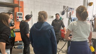 News Gruppe junger Menschen in Werkstatt beim Zuhören einer Person