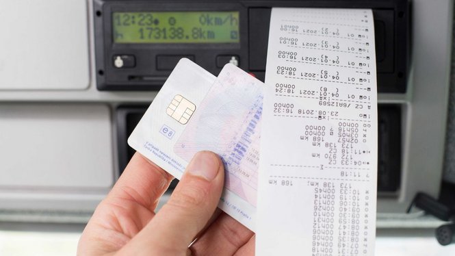 Home Hand hält Fahrerkarte und gedruckten Fahrtenschreiberbeleg vor Tachometeranzeige