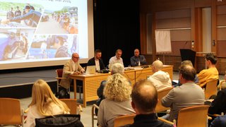 News Menschen bei einer Veranstaltung mit Präsentation zum Blue Ride Event 2024