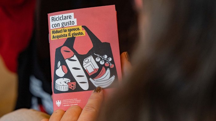 Mittelschule Dorf Tirol: Berufe praxisnah erleben Eine Hand hält eine Broschüre zum Recycling und zur Vermeidung von Lebensmittelverschwendung