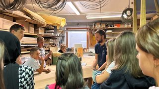 News Gruppe Kinder lernt in Werkstatt von einem Mann Holzbearbeitung
