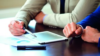 Manifestazioni Due professionisti discutono dati su tablet e documenti cartacei