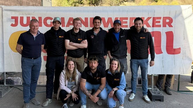 Home Gruppe junger Handwerker posiert vor Banner mit Schriftzug Jungjanwerker Schweiz