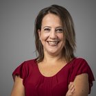 Jobs Porträt einer lächelnden Frau in rotem Kleid vor grauem Hintergrund