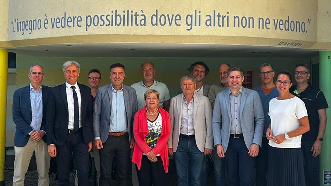 Home Gruppenfoto vor Wand mit Enrico Mattei Zitat in Italienisch