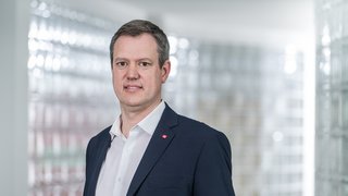 News Ritratto di un uomo in giacca davanti a parete di vetro in ufficio