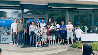 News Gruppe von Kindern und Erwachsenen mit Urkunden und Preisen vor einem Gebäude