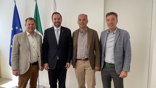 News Vier Männer in Anzügen vor EU-, Italien- und weiteren Flaggen