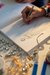 Home Hand zeichnet Modedesign in Skizzenbuch mit Schmuck im Vordergrund